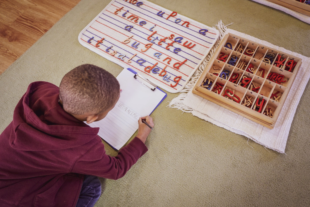 A small boy is learning letters.